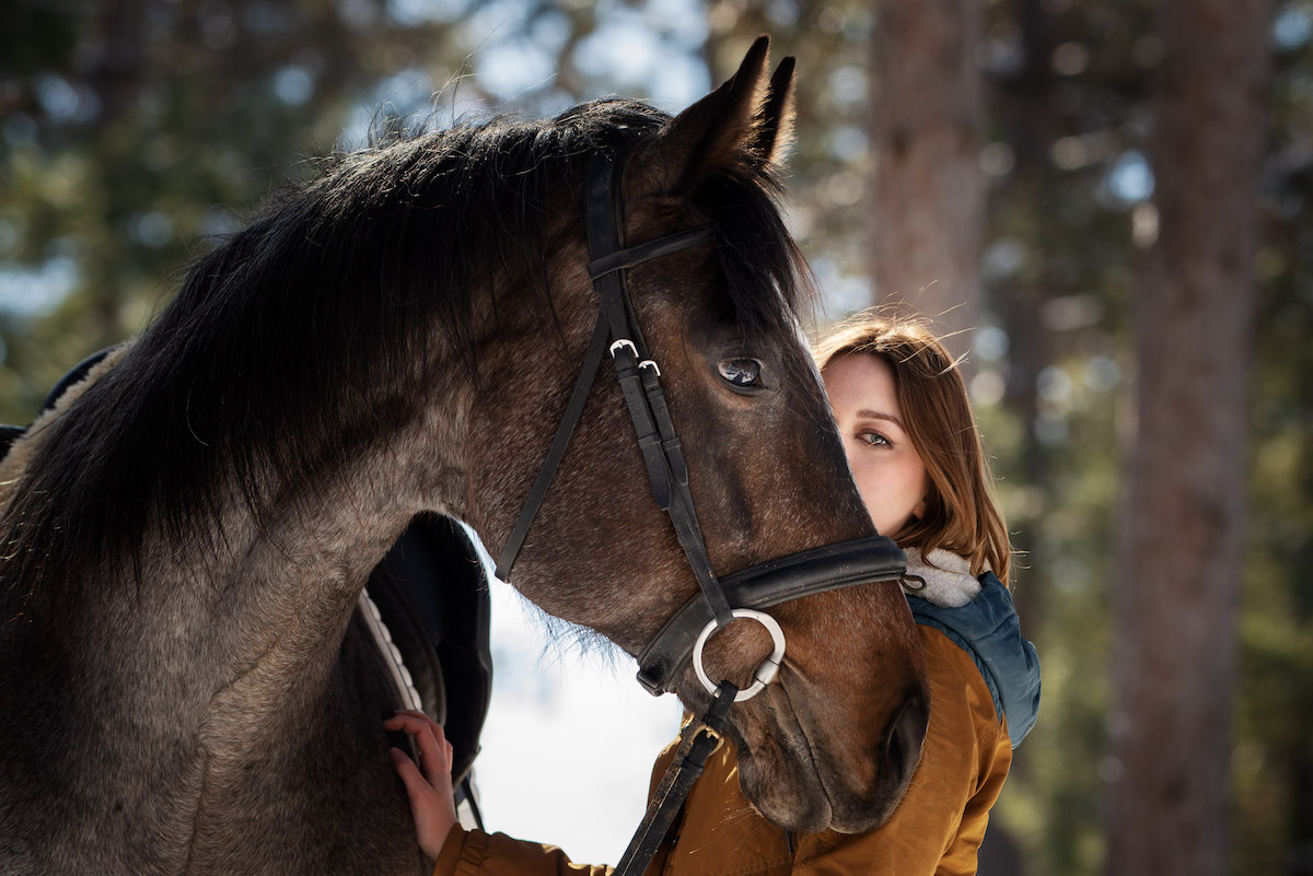 High School Senior Session portrait of a non-binary boy and girl posing with a horse, an appendix mare, in a dramatic setting, captured by Eliza Porter Photography in Eau Claire, Wisconsin